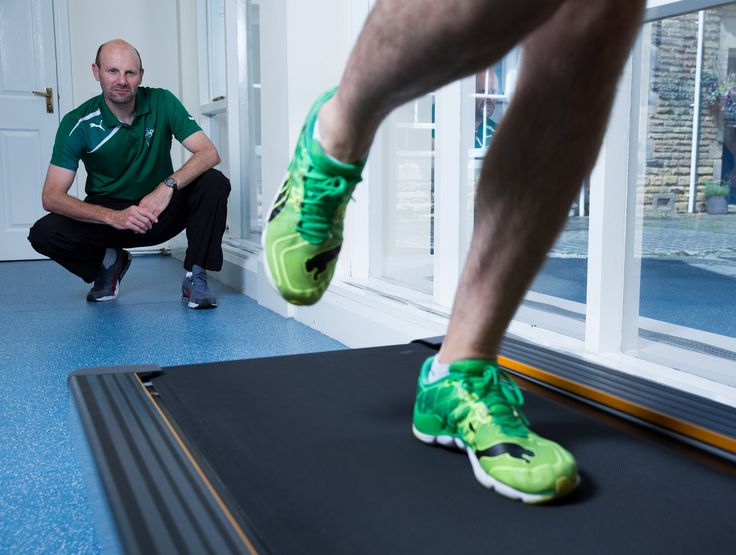 Running coach observing athlete on treadmill