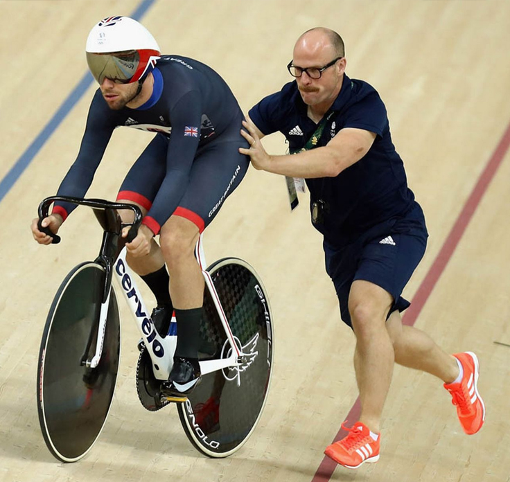 Cycling Coach providing support for athlete cyclist