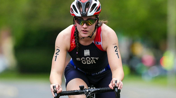 Female athlete cyclist taking part in a triathlon race