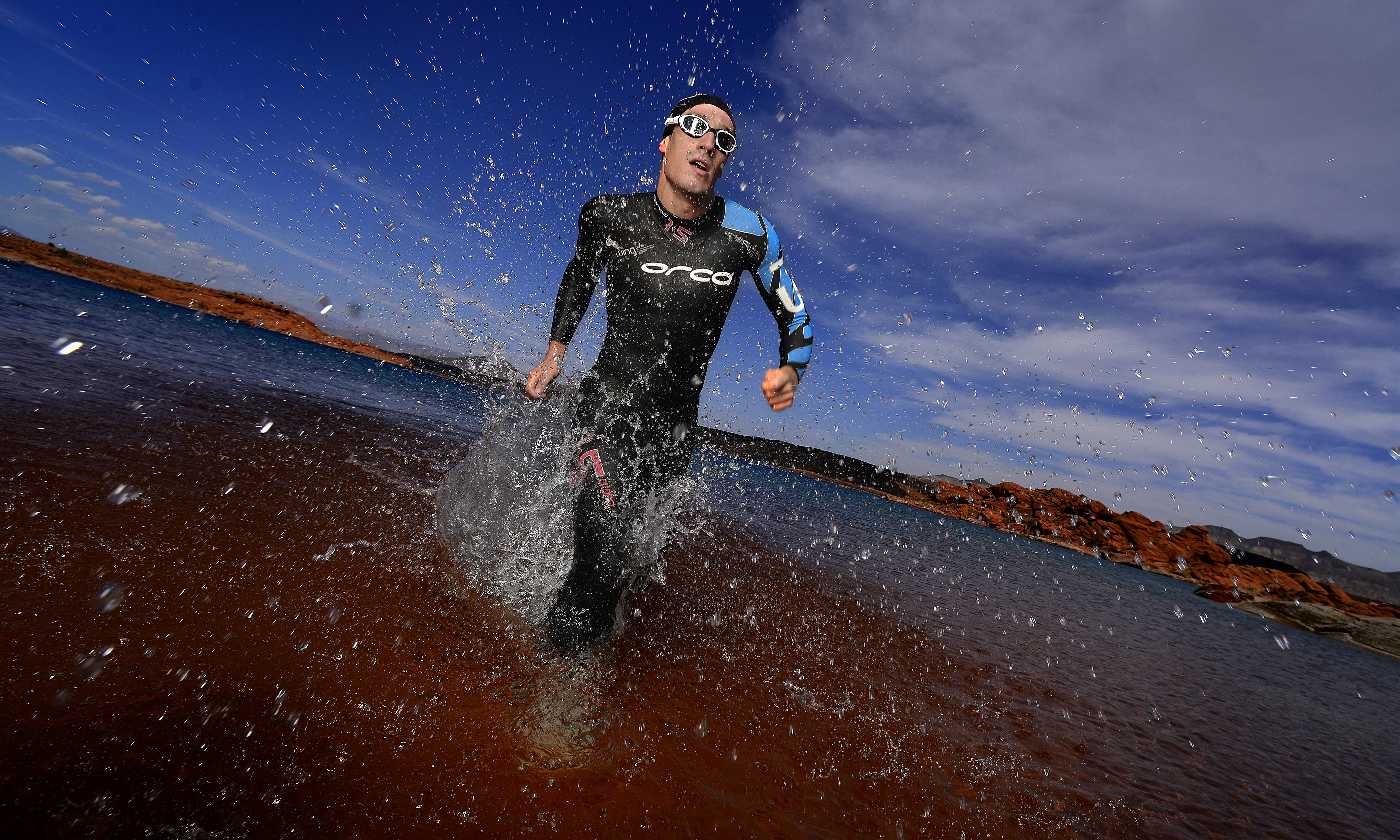 Athlete Swimmer running out of the water to finish a race