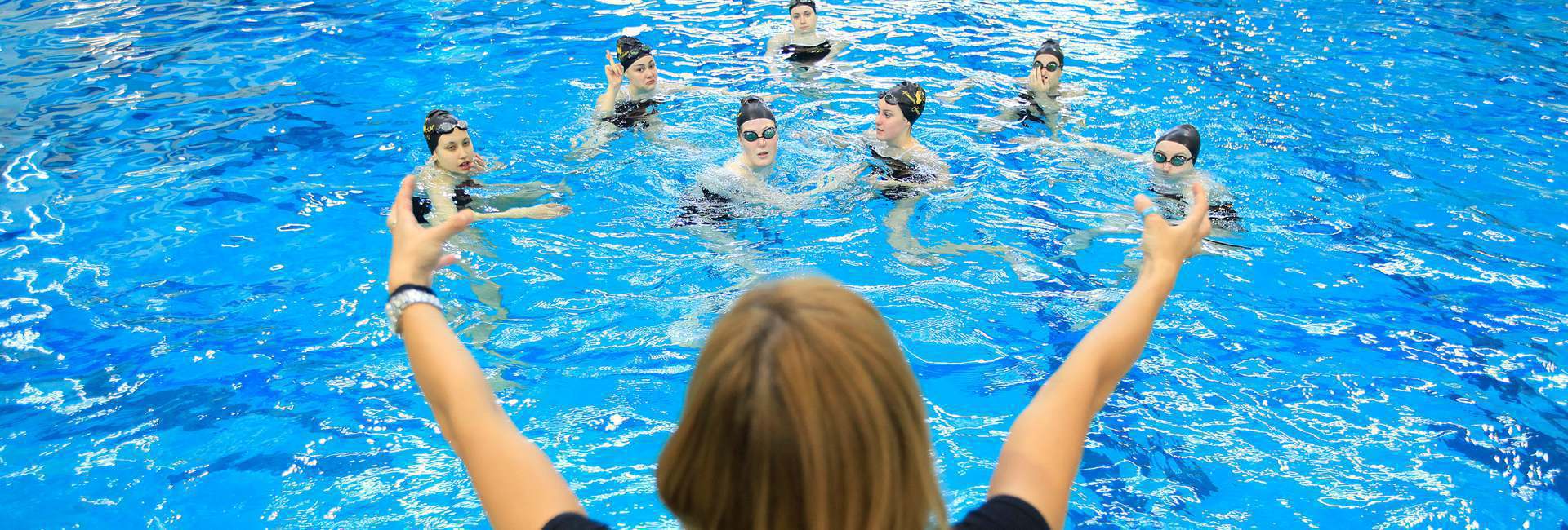 Coach providing swimmers with advice between races.