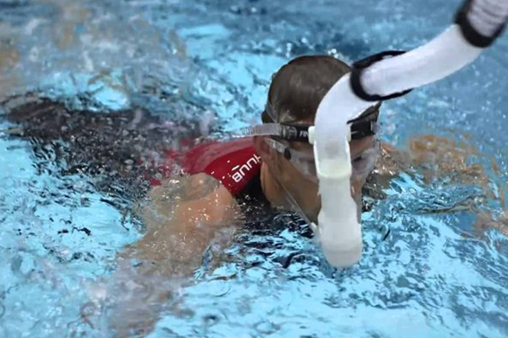 Athlete swimmer using snorkle to aid breathing on a race