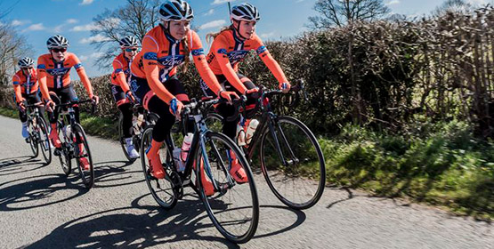 Group of cyclists cycling down a road