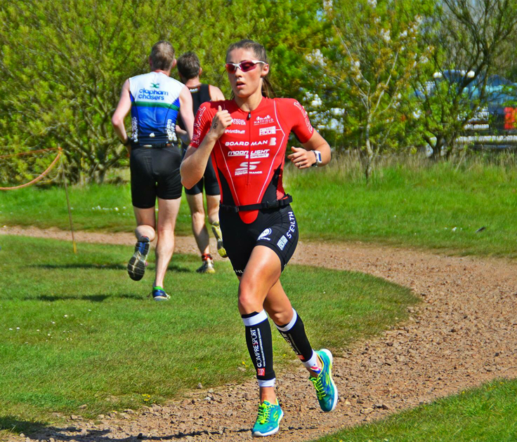 Female athlete runner performing running excersies pre event