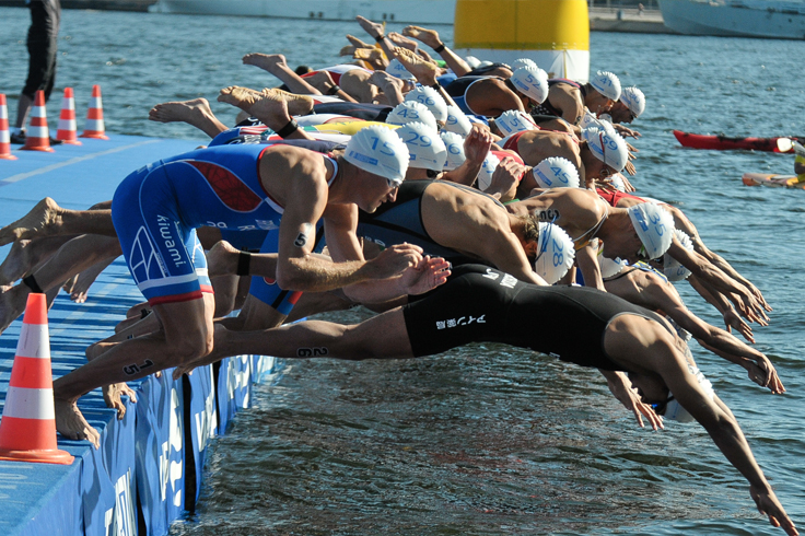 Group of Athlete swimmers jumping into pool ready to begin race